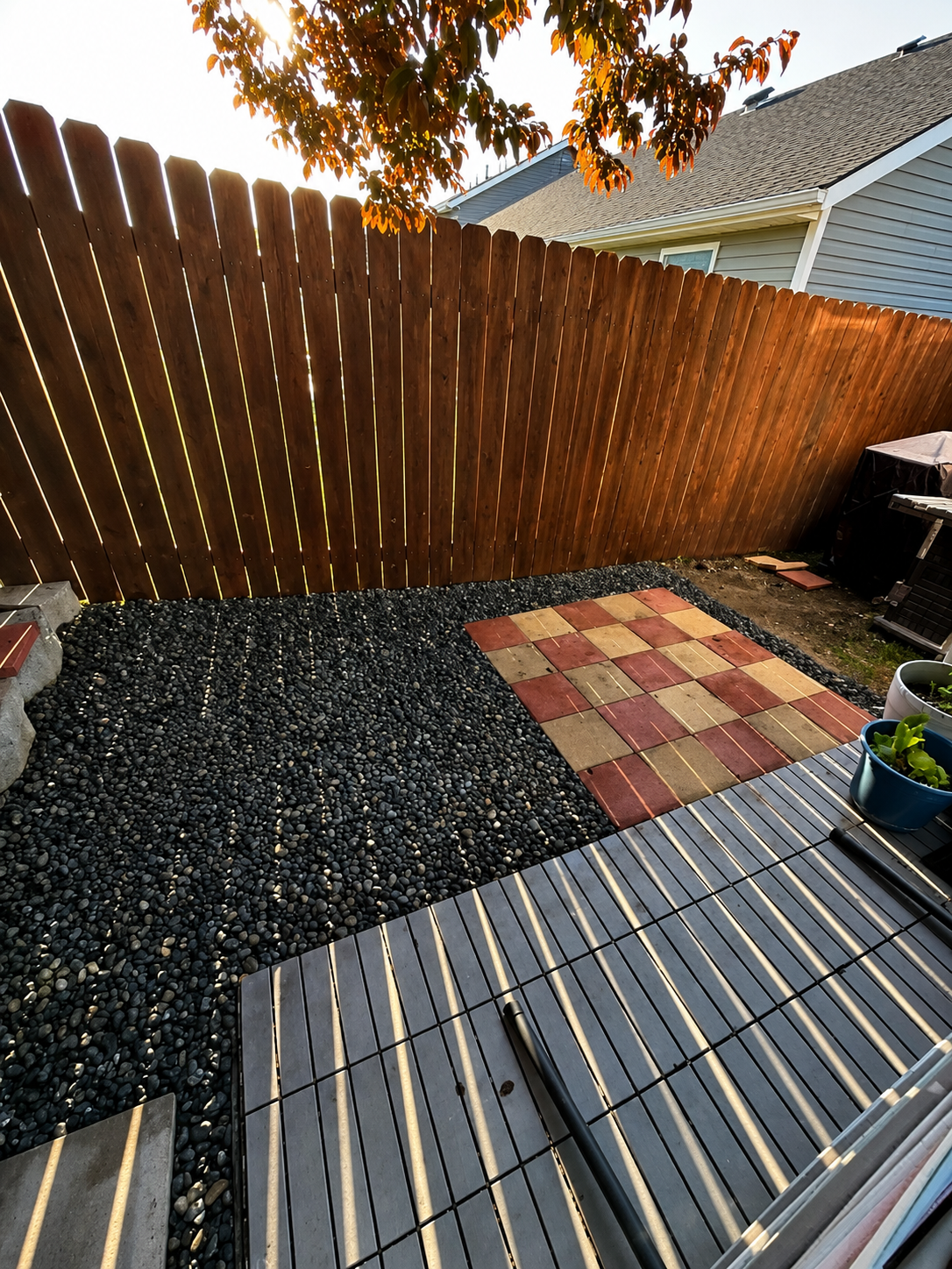 Rock and gravel yard transformation with interlocking deck tiles